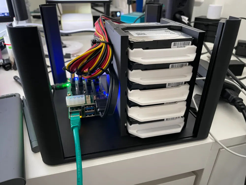 Open black chassis showing the computer board, five-drive stack, and power cables